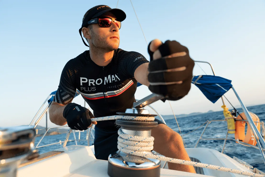 Natural Pharmaceuticals ProMan® Plus Żeglarz w stroju sportowym ProMan® Plus obsługuje wciągarkę żaglową na jachcie podczas rejsu.